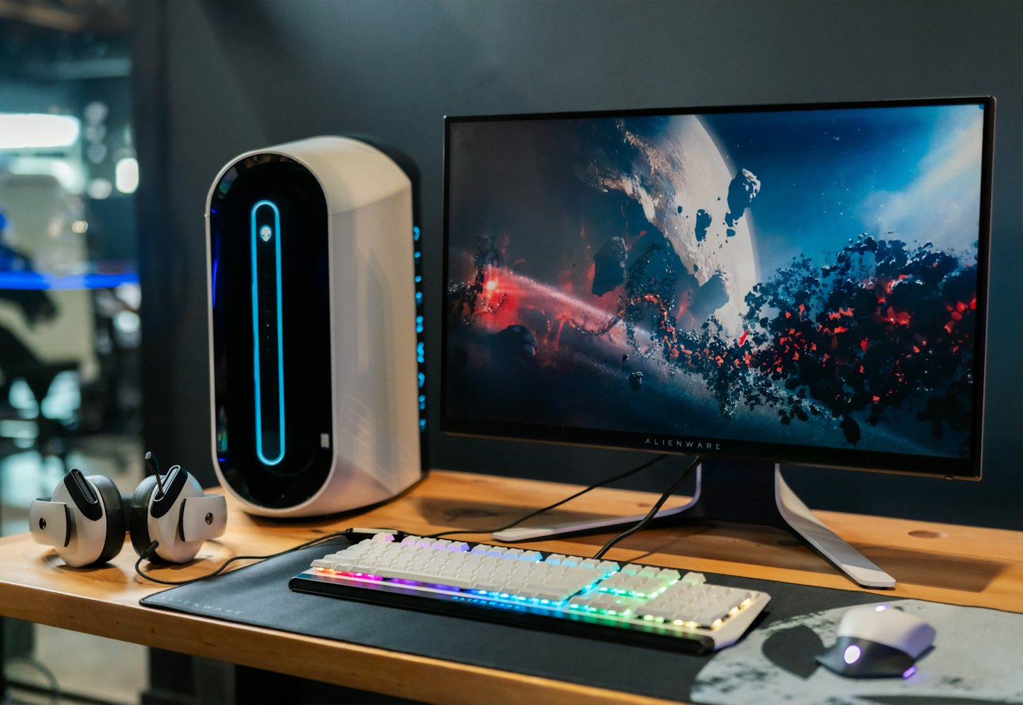 Modern gaming computer with blue LED accents on wooden desk.