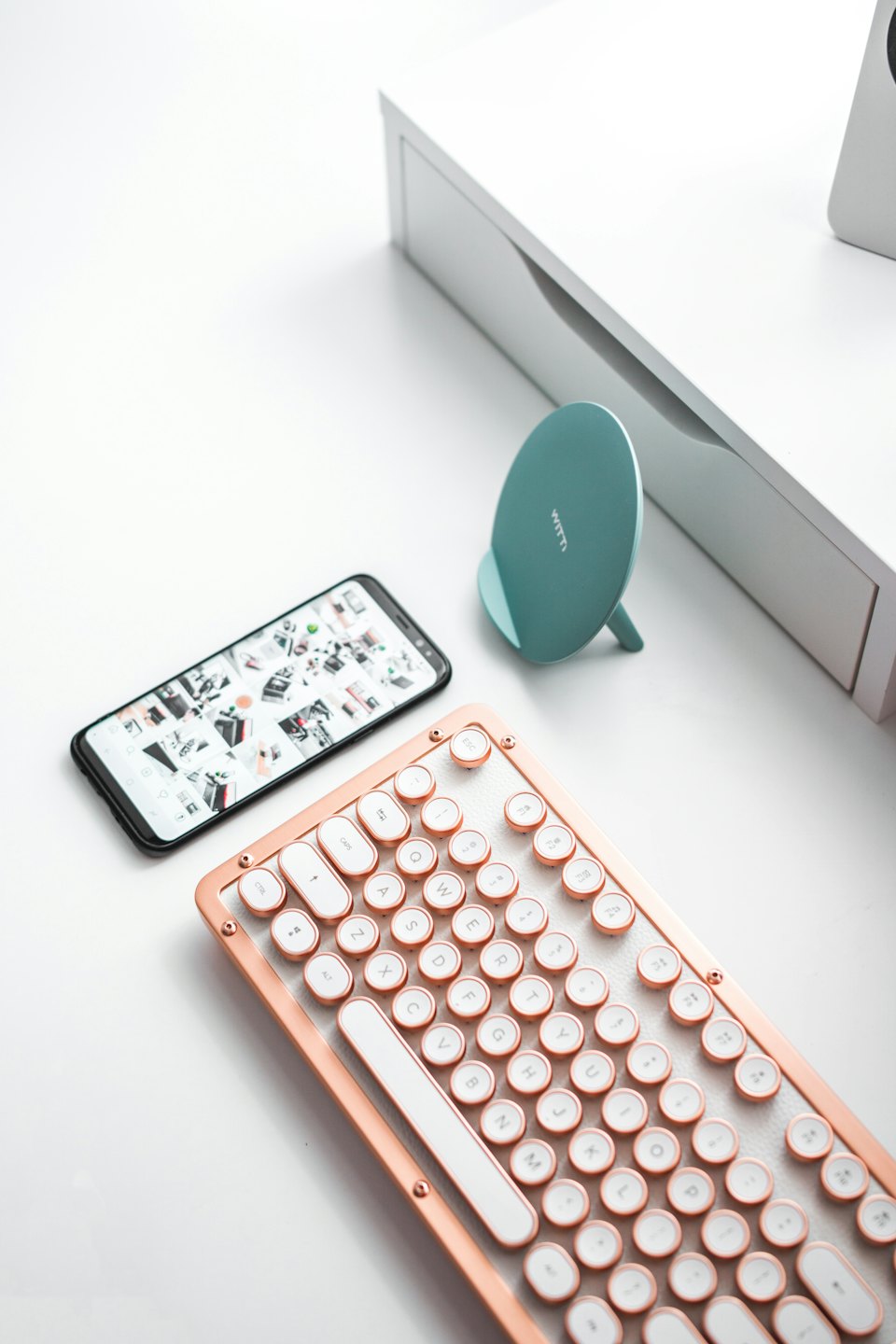 Retro mechanical keyboard and smartphone on a modern desk.