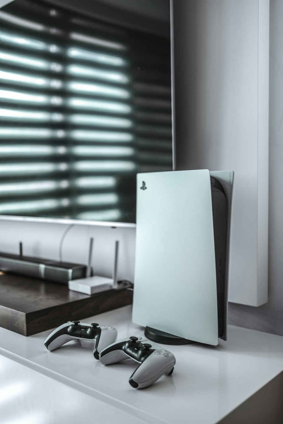 PlayStation 5 console and controllers on a white surface.